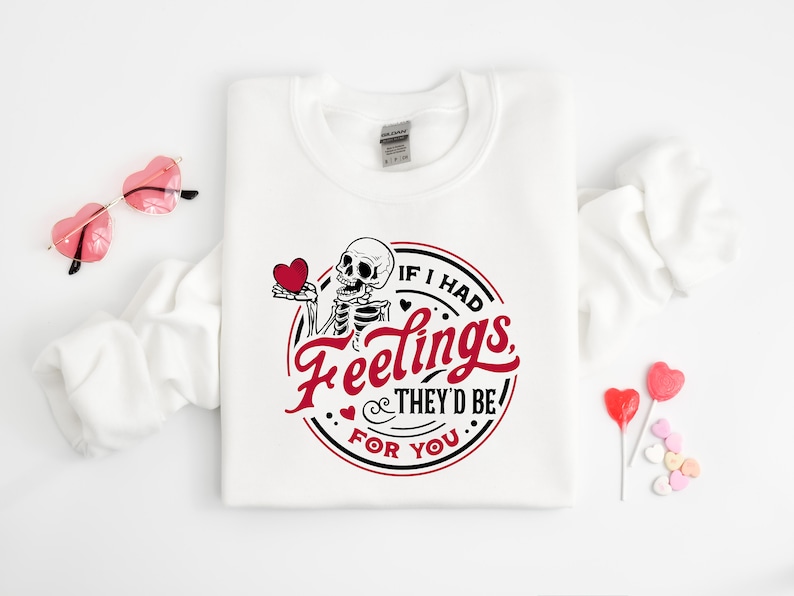 May include: White sweatshirt with a skeleton holding a red heart and the text "If I had feelings, they'd be for you".