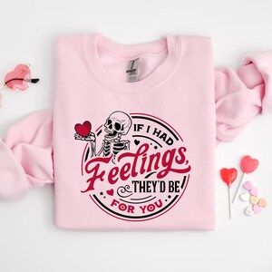 May include: Pink sweatshirt with a skeleton holding a heart and the text "If I had feelings, they'd be for you".