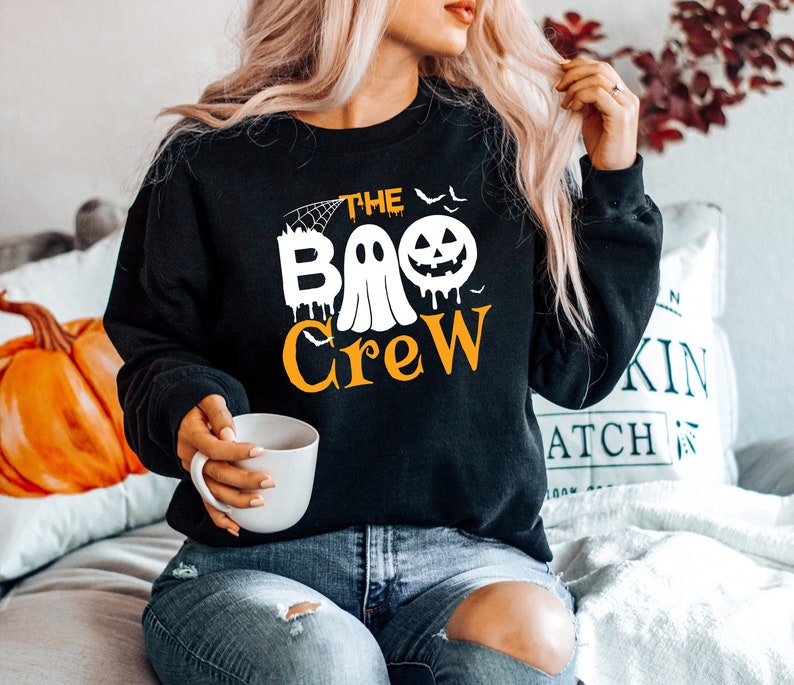 May include: Black sweatshirt with a white ghost and pumpkin graphic and the text "The Boo Crew".