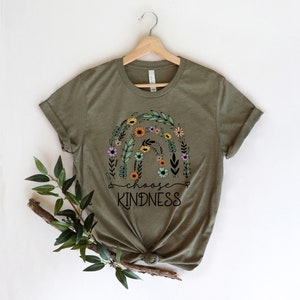 K&ouml;nnte beinhalten: Ein gr&uuml;nes T-Shirt mit einem floralen Regenbogen-Design und dem Text "choose kindness" in Schwarz.