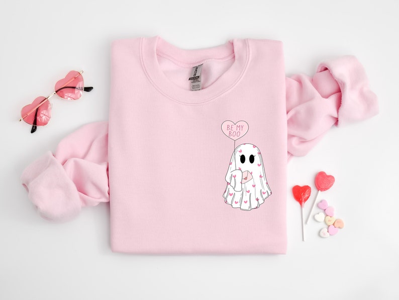 May include: Pink sweatshirt with a white ghost holding a heart balloon that says "Be My Boo".
