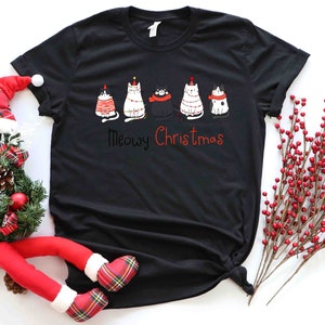 May include: Black t-shirt with a graphic of five cats wearing Christmas hats and the text "Meowy Christmas".