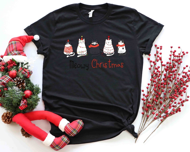 May include: Black t-shirt with a graphic of five cats wearing Christmas hats and the text "Meowy Christmas".