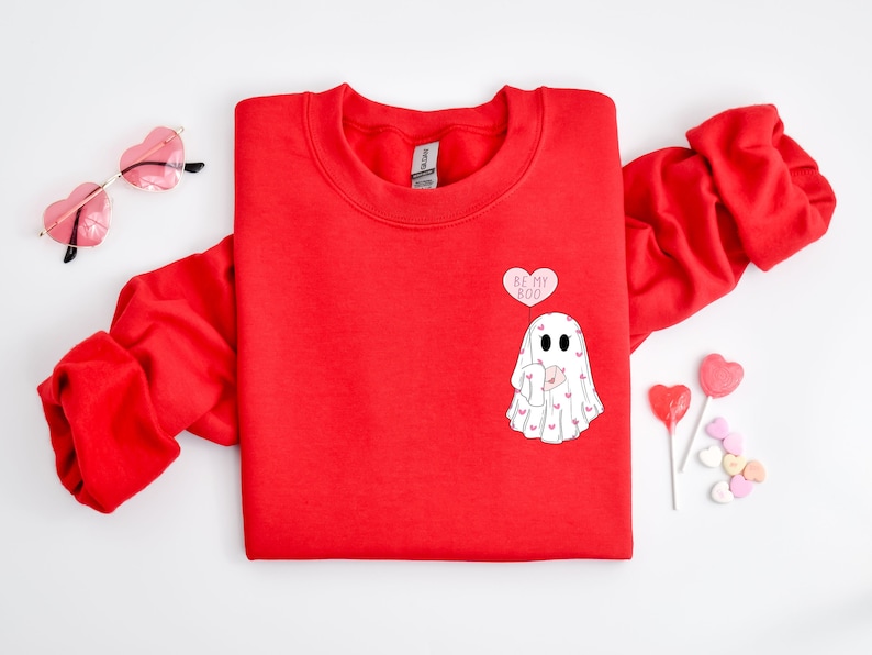 May include: Red sweatshirt with a white ghost graphic and the text "Be My Boo" in a pink heart-shaped balloon.