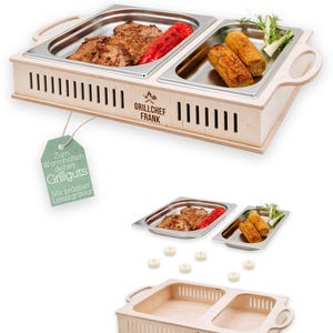 May include: A wooden food warmer with two stainless steel trays, holding grilled meats and vegetables. The warmer has handles and a slotted design. The text "Grillchef Frank" is visible on the front.