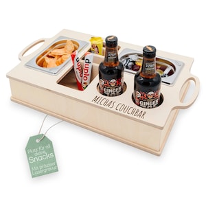 Könnte beinhalten: Ein Holz-Snacktablett mit Fächern für Chips, Süßigkeiten und Getränke. Das Tablett hat eine lasergravierte Inschrift mit dem Text "Michas Couchbar".