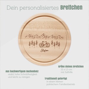 May include: A round wooden cutting board with a mountain and bicycle design. The board is made of beechwood and measures 9.8 inches in diameter and 0.6 inches thick. The name "Stefan" is engraved on the board.