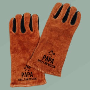 May include: A pair of brown leather grilling gloves with black accents on the fingers. The gloves have the text "PAPA GRILLT AM BESTEN" printed in black, along with a graphic of crossed grilling tools.