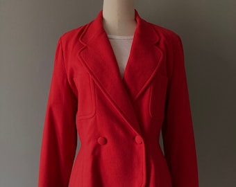 May include: A red double-breasted blazer with a fitted waist and long sleeves. The blazer has a classic lapel collar and two buttons at the front.