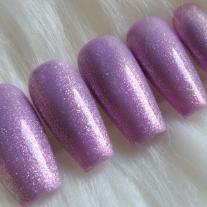 Presse violette étincelante sur les ongles