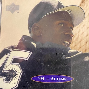 Peut inclure: Carte de collection sportive avec un homme portant une casquette de baseball et un maillot avec le numéro 45. La carte a un ovale bleu et or qui dit '94 - AUTOMNE'. La carte est dans une pochette de protection.