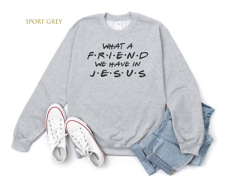 Pu&ograve; includere: Una felpa grigia con la scritta "WHAT A F.R.I.E.N.D WE HAVE IN J.E.S.U.S" stampata su di essa.