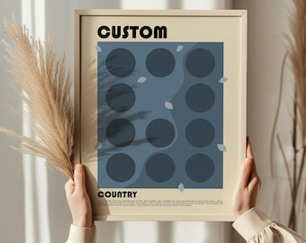 May include: A framed art print with the word "CUSTOM" at the top and "COUNTRY" at the bottom. The artwork features a blue background with dark blue circles and abstract shapes. The frame is a light beige color.