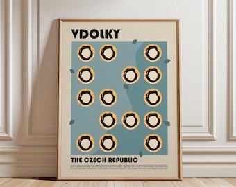 May include: A framed poster featuring the text VDOLKY and THE CZECH REPUBLIC. The design displays a grid of fourteen illustrations of round pastries with dark centers on a blue background, accented by small green leaf shapes.