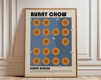 May include: A framed poster featuring the text BUNNY CHOW and SOUTH AFRICA in black, bold font. The central design displays a grid of orange bowls filled with curry on a blue background, accented by small light blue leaf shapes on a cream field.