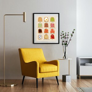 May include: A framed print depicting a chart of various toast toppings, including avocado, bacon, peanut butter, and jam. The print is displayed on a white wall in a living room setting with a yellow armchair, a side table, and a television.