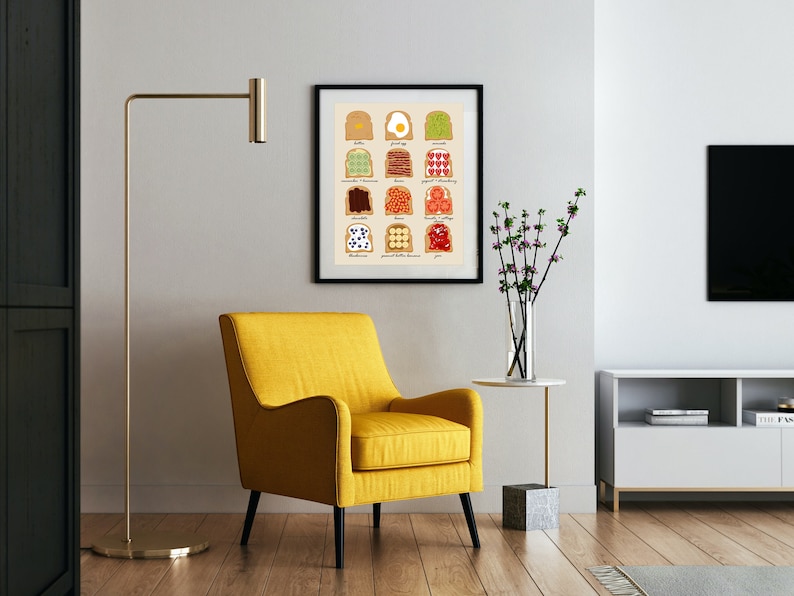 May include: A framed print depicting a chart of various toast toppings, including avocado, bacon, peanut butter, and jam. The print is displayed on a white wall in a living room setting with a yellow armchair, a side table, and a television.