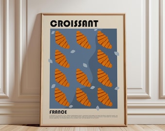 May include: A framed poster featuring the word CROISSANT at the top and FRANCE at the bottom. The center displays a blue rectangular field with twelve orange croissant illustrations and small light blue leaf shapes. Text at the bottom describes the pastry.
