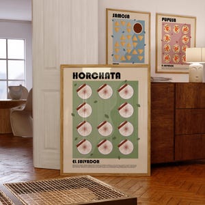 May include: A framed wall art print titled HORCHATA EL SALVADOR featuring a grid of twelve circular illustrations of horchata drinks with cinnamon sticks on a sage green background, with small text at the bottom and a light wood frame.