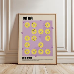 Pode incluir: Um pôster emoldurado com um design gráfico de alimentos amarelos em forma de anel com centros verdes em um fundo roxo. As palavras "BARA" e "SURINAME" são exibidas. O pôster está em uma moldura marrom claro.