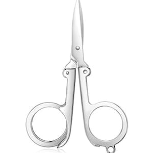 May include: A pair of small, silver folding scissors. The scissors have a pointed tip and two finger holes. The blades are closed, and the scissors are designed to fold for compact storage. The scissors are on a white background.
