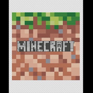 May include: Cross-stitch design featuring the word "Minecraft" in pixelated gray letters. The background depicts a blocky landscape with green grass, brown earth, and gray stone elements, all rendered in a cross-stitch style.
