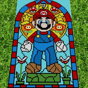 May include: A crochet pattern of a stained glass window featuring a pixelated Super Mario character standing on a green block. The window is surrounded by a red and blue border.