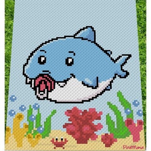 May include: A blue cartoon shark with a big mouth and white teeth is swimming in the ocean. The shark is surrounded by green seaweed and red coral. The image is pixelated and has a retro feel.