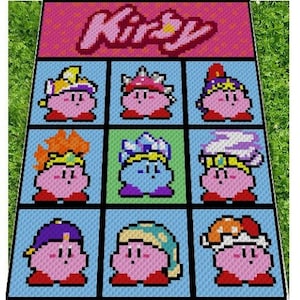 以下が含まれることがあります： ピンク色の「Kirby」の文字が上部に配置された、ピクセル化されたラグ。下には、それぞれユニークな帽子やアクセサリーを身に着けた、さまざまなバージョンのカービィのキャラクターが描かれた9つの正方形があります。背景は水色です。