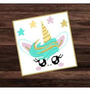 May include: A white card featuring a cartoon unicorn with a gold horn and turquoise mane. The unicorn has eyelashes and a pink nose. The card is decorated with gold and pink stars.