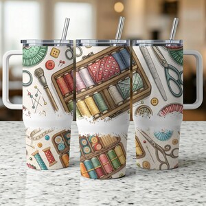 May include: Three stainless steel tumblers with lids and straws. Each tumbler features a different design with a sewing theme. One tumbler has a design of spools of thread, buttons, and needles. Another tumbler has a design of a sewing box with spools of thread. The third tumbler has a design of scissors, buttons, and a thimble.
