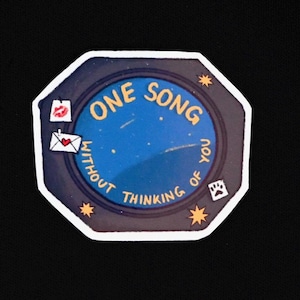 Könnte beinhalten: Ein achteckiger Aufkleber mit einer dunkelblauen Mitte und dem gelben Text ONE SONG WITHOUT THINKING OF YOU. Der Rand ist dunkelgrau mit kleinen gelben Sternen, einem roten Lippenstiftkuss, einem weißen Umschlag mit rotem Herz und einer Pfote.