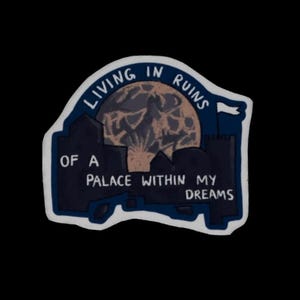 Könnte beinhalten: Ein dunkelblauer Aufkleber mit dem Text "LIVING IN RUINS OF A PALACE WITHIN MY DREAMS" in Weiß. Das Design umfasst einen Vollmond und Silhouetten von Gebäuden. Der Aufkleber hat einen weißen Rand und ist vor schwarzem Hintergrund.