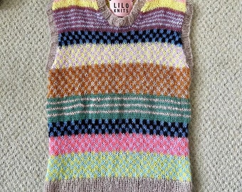 Puede incluir: Un chaleco de punto multicolor con cuello en V. El chaleco presenta rayas horizontales en tonos de rosa, azul, amarillo y marrón. La etiqueta dice "LILO KNITS". El chaleco está hecho de un hilo suave y texturizado.