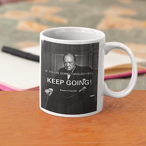 May include: White ceramic mug featuring a black and white image of Winston Churchill. The quote "If you're going through hell, keep going!" is printed on the mug.