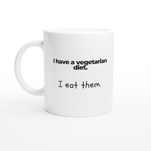 May include: White ceramic mug with black text that reads "I have a vegetarian diet. I eat them."