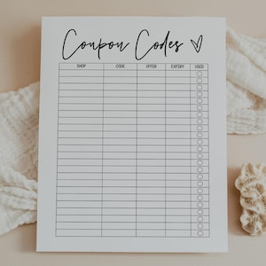 May include: A white coupon code tracker with the words "Coupon Codes" in cursive script. The tracker has columns for shop, code, offer, expiry, and used. A decorative coral and a white cloth are in the background.