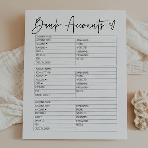 以下が含まれることがあります： 手書きフォントの「Bank Accounts」というタイトルの白い紙。紙には、アカウントの詳細、銀行情報、クレジット制限のフィールドがある3つのセクションがあります。白い布と小さなサンゴのような物体が背景にあります。
