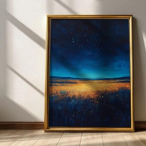 May include: A framed landscape painting depicts a field of golden grass under a dark blue night sky filled with stars. The artwork is encased in a gold frame, creating a striking contrast against the natural scene.