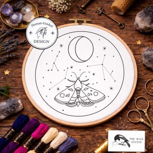 May include: Embroidery hoop with a black and white moth and constellation design. The design includes a crescent moon, stars, and the text "Human-Guided Design". The Wild Stitch logo is in the bottom right corner.