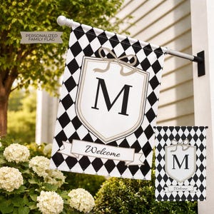 May include: A personalized family flag with a black and white diamond pattern. The flag features a white shield with a bow and the letter "M", and a banner that says "Welcome". A smaller version of the flag is also visible.