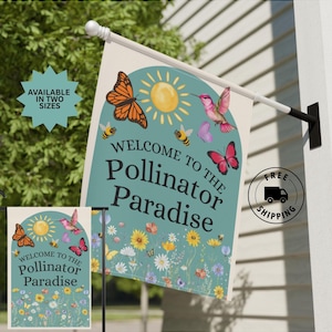 May include: A garden flag with the text "Welcome to the Pollinator Paradise" featuring illustrations of butterflies, bees, and flowers. The flag has a teal background with a sun and arch design. Available in two sizes.