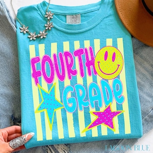 Op de afbeelding: Een Lagoon Blue t-shirt met de woorden "FOURTH GRADE" in roze en turquoise, een gele smiley en twee sterren. Het shirt heeft gele verticale strepen en de woorden "COMFORT COLORS" op het label.