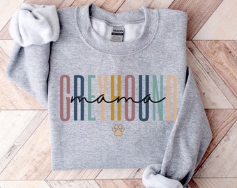 May include: Gray sweatshirt with the text "Greyhound mama" in colorful vertical stripes and a paw print below.