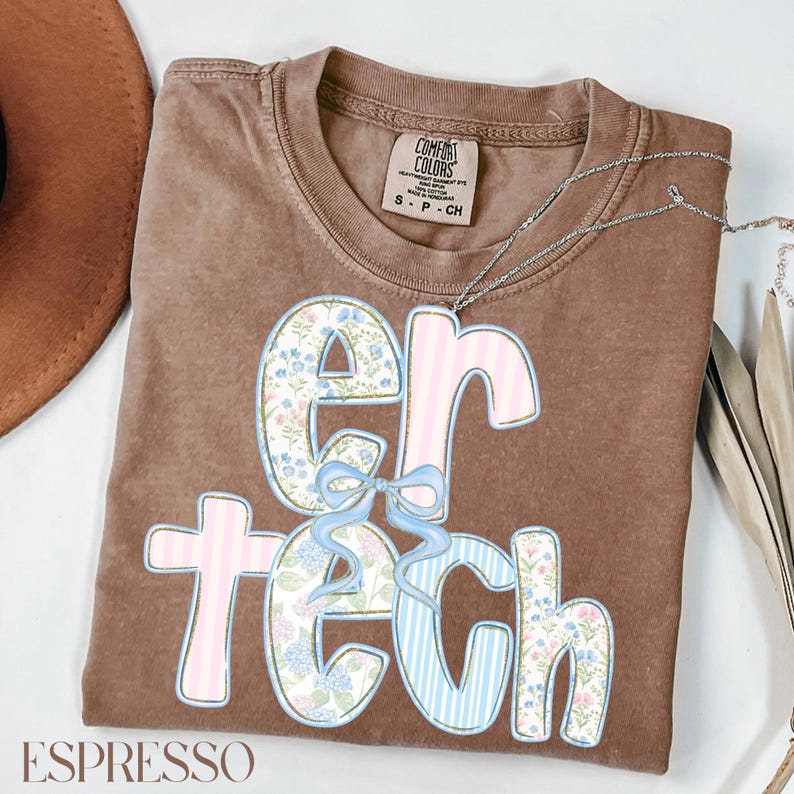 May include: A brown t-shirt with the word "ER TECH" in a floral and striped design. The letters are in pink, blue, and white, with a light blue bow. The shirt has a crew neck and short sleeves. The word "ESPRESSO" is at the bottom.