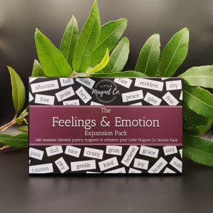 May include: A burgundy box with the words "The Feelings & Emotion Expansion Pack" printed on the front. The box contains 240 emotion-themed poetry magnets to enhance your Little Magnet Co. Starter Pack. The magnets are arranged in a grid pattern and feature words like "affection", "free", "pride", "rant", "reckless", "shy", "peace", "glee", "fear", "pain", "dull", "nice", "crazy", "grim", "believe", "grace", "coy", "caution", "pity", "gentle", "kind", "joy", "brave", and "safe".