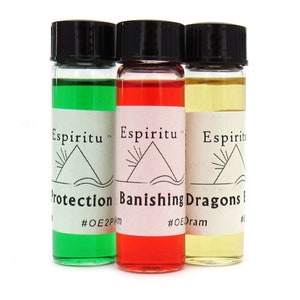 May include: Three small glass bottles with black caps and labels. The bottles contain green, red, and yellow liquids. The labels read "Espiritu" and have a pyramid symbol. The labels also have text that reads "Protection", "Banishing Dragons", and "Dragons Blood".