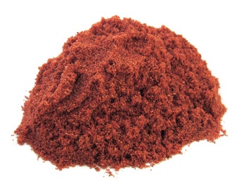 May include: A pile of loose, dark red, finely ground spice.