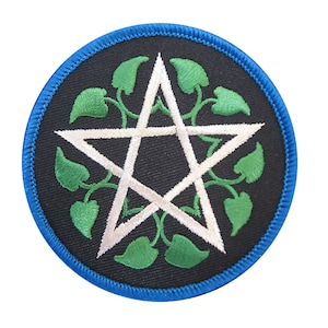 May include: Round black patch with a white pentagram design, surrounded by green leaves and vines. The patch has a blue border. The design is embroidered on the patch.