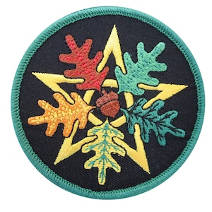 May include: Embroidered patch with a five-pointed star in yellow, surrounded by four oak leaves in red, orange, yellow, and green. The center of the star has a brown acorn.